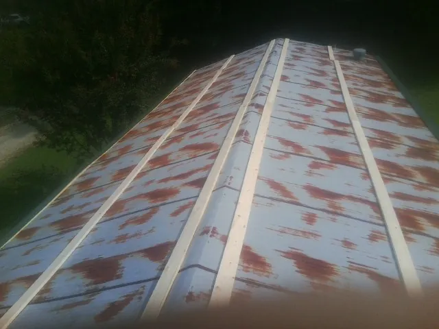 Rusted metal roof panels with new wood purlins before replacement — Storm Damage Roof Repair in Bottineau by Roofing Brothers