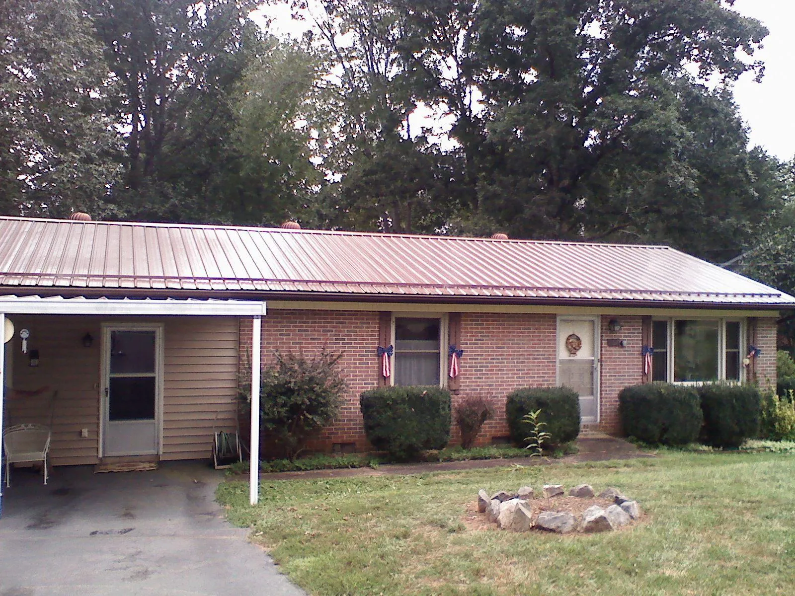 Bronze metal roof and carport on a brick ranch home — Roof Repair work by our crew in Bottineau